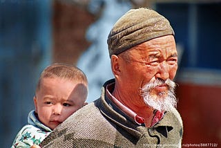 A child being carried by an old man in Eastern Qazaqstan.