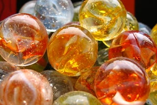 a group of orange, yellow, and blue colored glass marbles