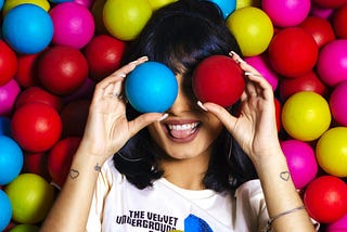 Photo Of Woman Lying On Assorted-Colored Balls