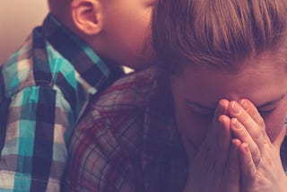 Crying unhappy mother with child at home