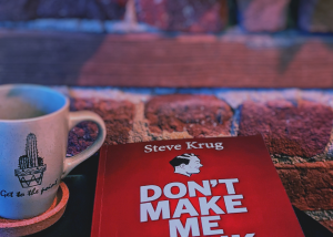 Book on coffee table with cup of tea against brick wall