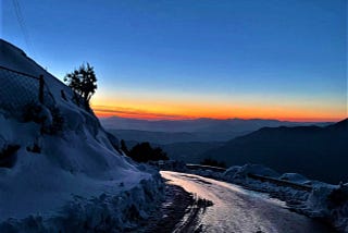 View of a sunset from a snowy road