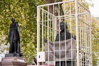 A picture of the Suffragette statue in Parliament square surrounded by fake prison bars