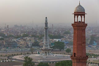 Minar-e-Pakistan, and a pillar of Badshahi mosque with walled city of Lahore in the background — Boost for Medium.