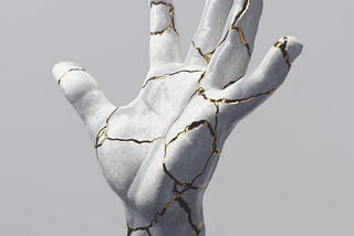 Picture of a white statue of a hand that has repaired from a previous shattering and looking beautiful with the cracks fixed with gold, representing the concept that things can look more beautiful after be repaired than they were before they broke.