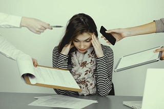 Stressed woman being handed a paper to sign and a phone call to take.