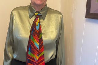 photo of author in shiny green gold blouse and multicolored silk tie