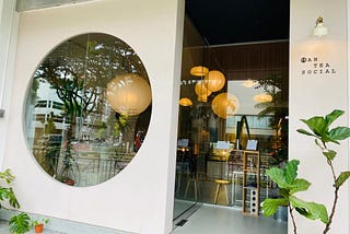 Entrance of Antea Social — a large light-coral color wall with a big circular cut-out for those curious to see what’s within.