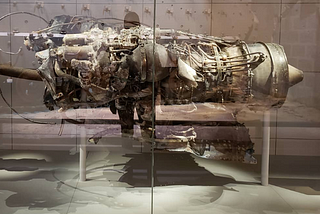 Burnt Black Hawk helicopter engine displayed in a museum.
