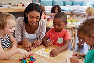 Educator working with young children using math manipulatives