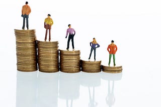 Figurines standing on stack of coins