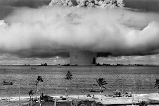 A black and white mushroom cloud explosion in the ocean.