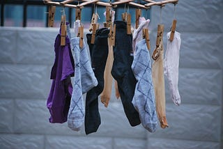 colorful socks hanging from a drying rack by clothespins