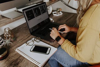 Woman typing on laptop on wooden desk