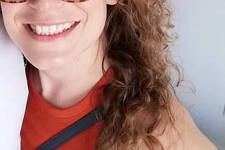 It’s me! A curly-haired, bespectacled woman in an orange top.