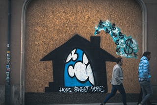 Street art of a house spewing dollars from the chimney
