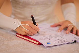 A bride signing her marriage certificate