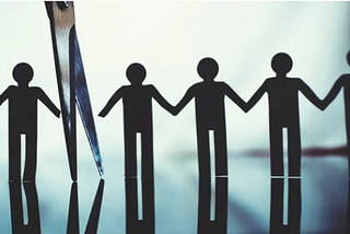 Image of a chain of paper people holding hands and scissors cutting one person off the chain.