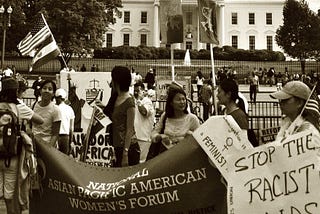 NAPAWF DC chapter holds a banner in protest of deportation raids in front of the White House in 2009.