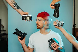 Man with red beanie can’t decide what camera to use