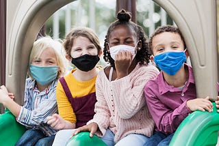 Children on playground wearing face masks