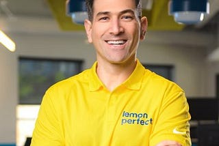 A headshot of Yanni Hufnagel in a yellow shirt that says “Lemon Perfect”