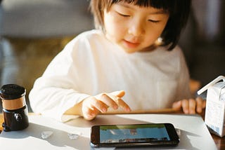 Kid watching content on their mobile screen.