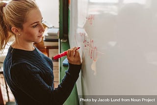 Close up of female student writing an equation on white board in classroom. Courtesy of Jacob Lund for The Noun Project.