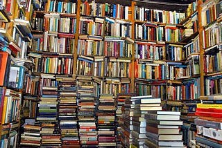 large pile of books and a bookshelf