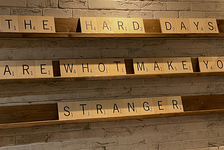 Blocks on shelf that spell out ‘The hard days are whot make you stranger’