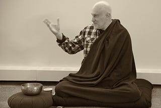 Meditation teacher Shinzen Young sitting next to a meditation bell.