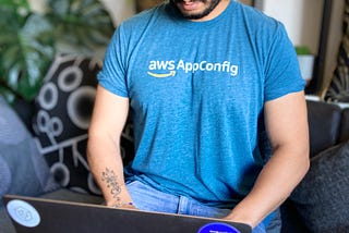 Photograph of a person on a laptop wearing an AWS AppConfig T-shirt