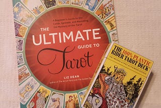 A deck of Rider-Waite-Smith tarot cards sits atop a tarot guidebook