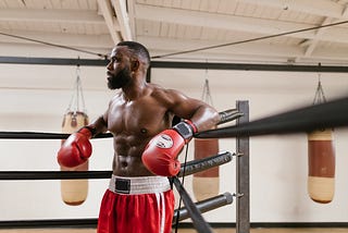 Sweaty boxer leaning on a boxing ring