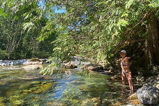 Woman in a bikini at the river surrounded by trees
