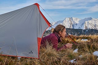 Women looking out from a tent in the Swiss mountains.