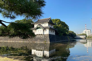 An corner photo of the tokyo palace space surrounded by trees and a river