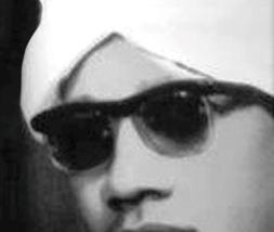 Black and white photo of Mahmoud Falah, a handsome young man in white turban and dark sunglasses.