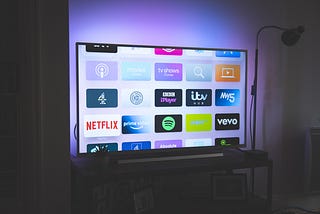 A flat screen TV that shows the icons for most streaming channels including Netflis and Amazon Prime