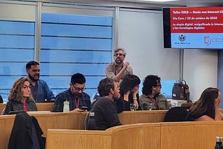 A presenter gives a talk to a room of digital rights advocates.