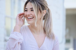 happy girl with hair in ponytail wearing white top