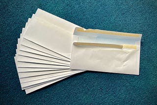 Several blank white envelopes. The top one is turned over and is crumpled.