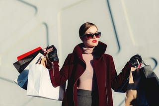 Photo of a woman proudly carrying her shopping bags.