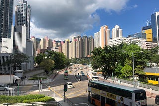 High rise buildings behind a busy road in Hong Kong.