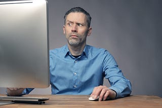 A man staring at a computer screen. One eyebrow is raised as if to say, “What the heck did I do and how do I undo it?”