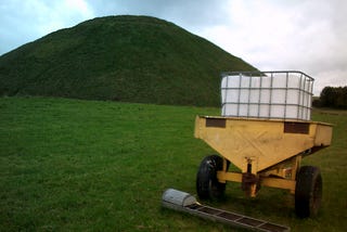Image of farm trailer in foreground of photograph of Silbury Hill, Wiltshire 2400BC