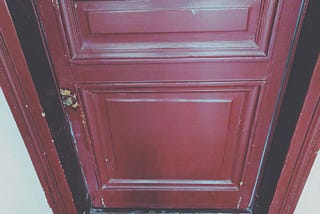 red door with welcome mat that reads home with a heart for the ‘o’