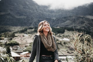 A young lady smiling by the countryside.