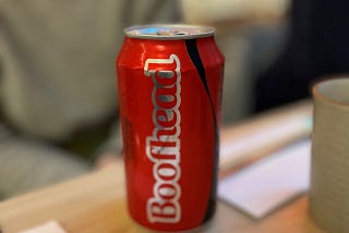 A can of Coca Cola with the word “boofhead” on it.