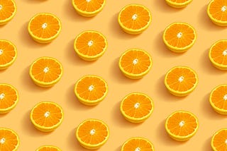 A light orange background with an array of halved oranges organized in a regular pattern. It makes you think of freshly squeezed orange juice!